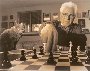 Lou Domanski at the chess board, with a furry apprentice looking on. Courtesy photo.