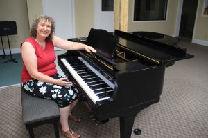 Top: Karin Wedemeyer sits at the 1962 Yamaha G-2 grand piano recently donated to MCS. Photo by Ben Olson.