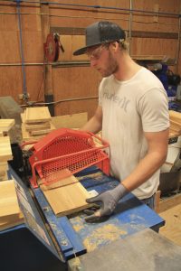 Employee Michael Wallace cuts short lengths of wood in the Chop Room at their Shingle Mill Road facility.  Photo by Ben Olson.